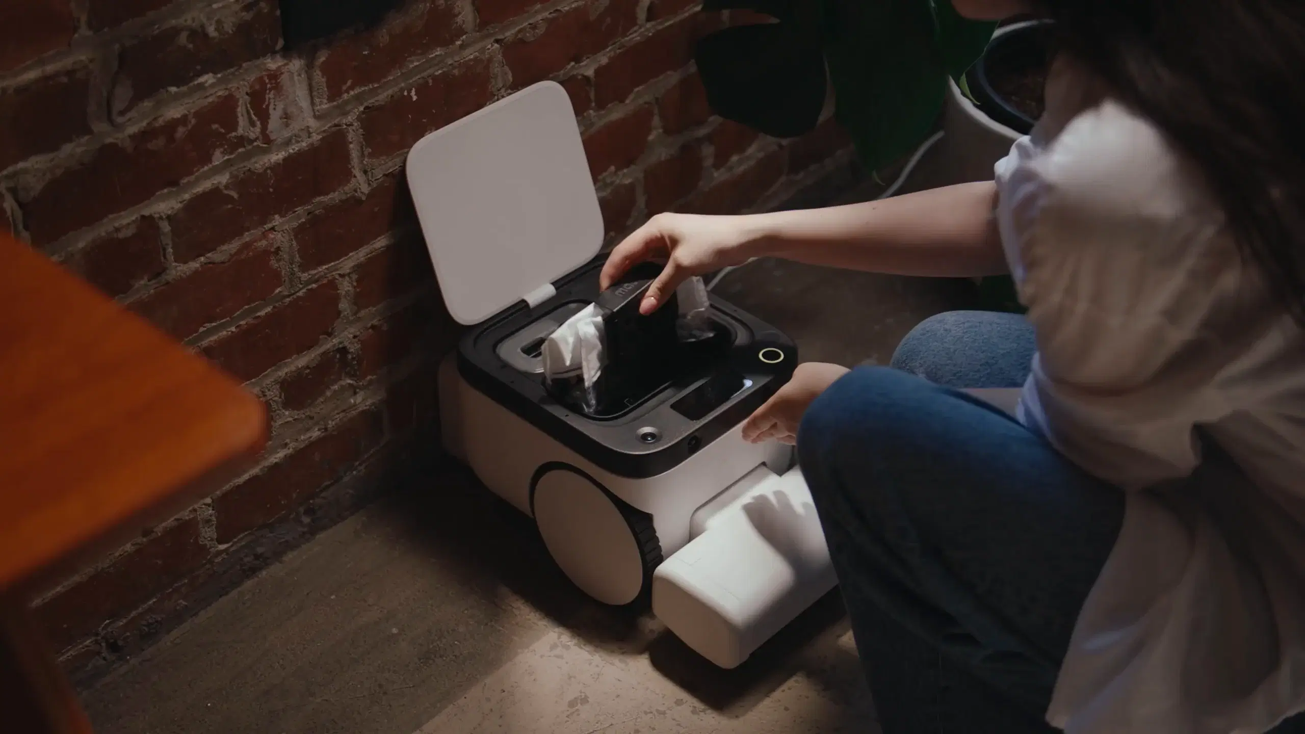 A person replacing Matic’s sealed HEPA bag over a trash can