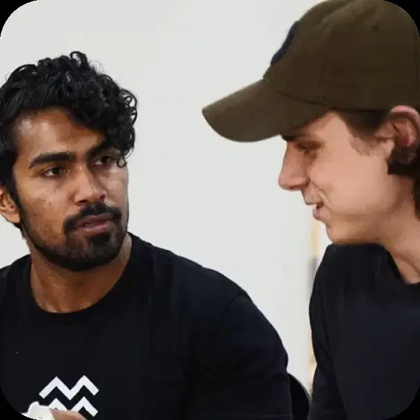 Two teammates talking through an idea at a table