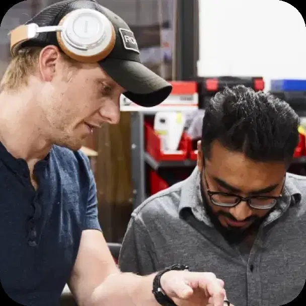 Two engineers inspecting hardware together at a workbench