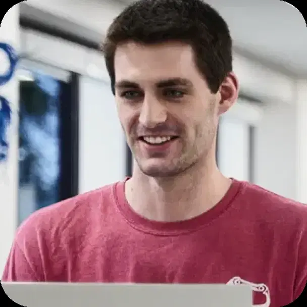 An engineer smiling at a laptop in the office