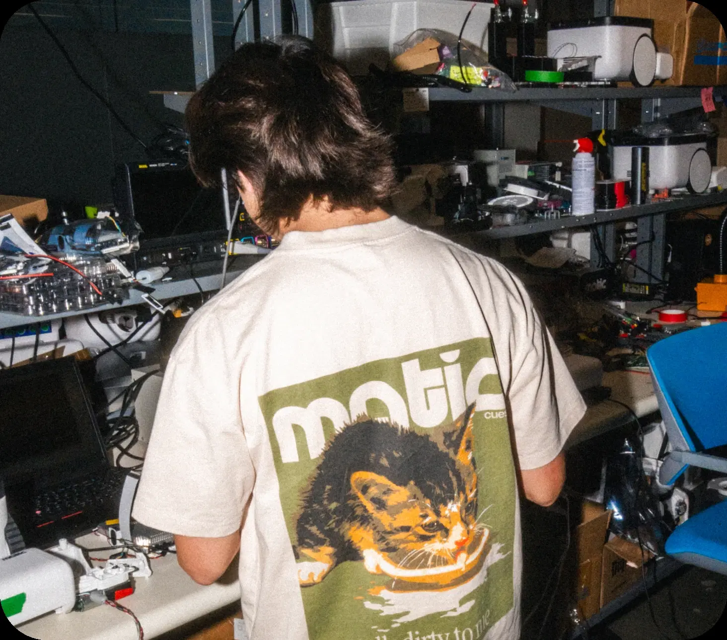 An engineer working at a Matic lab bench stacked with robot prototypes and equipment